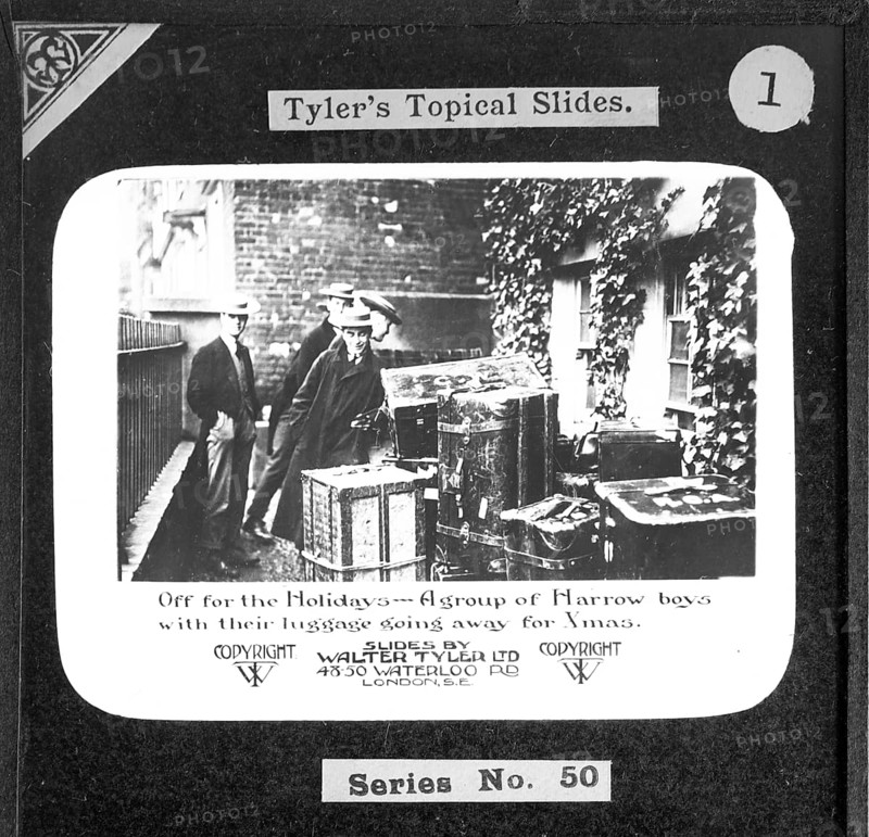 Off on holiday . A group of Harrow boys with their luggage on their way to the Christmas holidays. Walter Tyler Ltd. magic lantern slide circa 1910