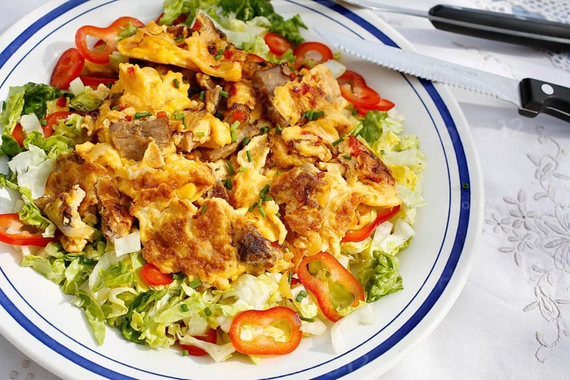 Swabian cuisine, cat's gruel, leftovers, utilisation of leftovers, meat with egg, Swabian scrambled eggs, vegetables, onions, arranged on plates, salad bed, salad hearts, red peppers, kitchen utensils, knife, fork, grandmother's kitchen, regional, home cooking, typical Swabian, traditional cuisine, food photography, studio, Germany, Europe