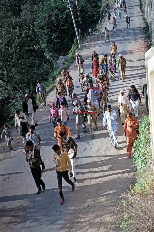 Musicians leading a wedding procession, veiled bride in purdah in small rickshaw, groom riding on donkey, Shimla or Simla, Himachal Pradesh, India, 1971, Asia