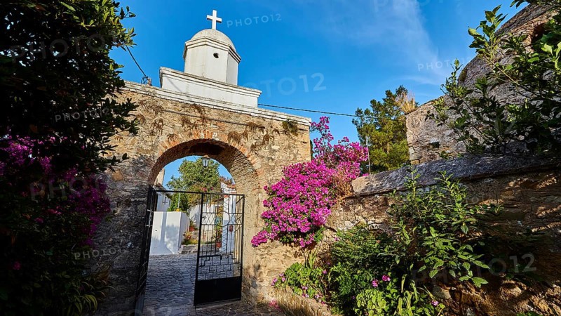 Old wall arch with a view of a church surrounded by flowering plants, Koroni, Byzantine fortress, nunnery, Peloponnese, Greece, Europe