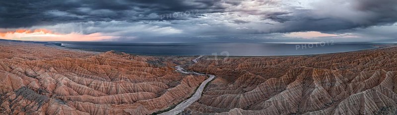 Panorama, landscape of eroded hills, badlands at sunset, Issyk Kul Lake in the background, aerial view, Canyon of the Forgotten Rivers, Issyk Kul, Kyrgyzstan, Asia