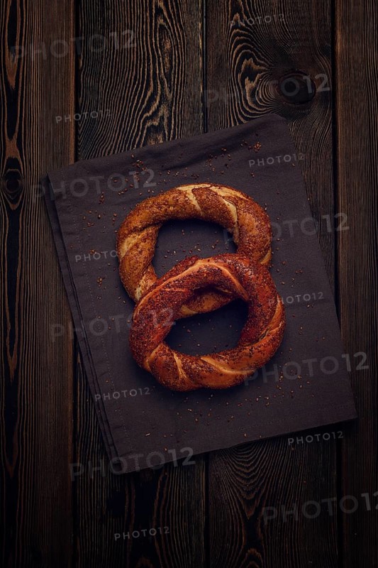 Traditional Turkish bagel Simit, Top view on a wooden table, vertical, no people, rustic style