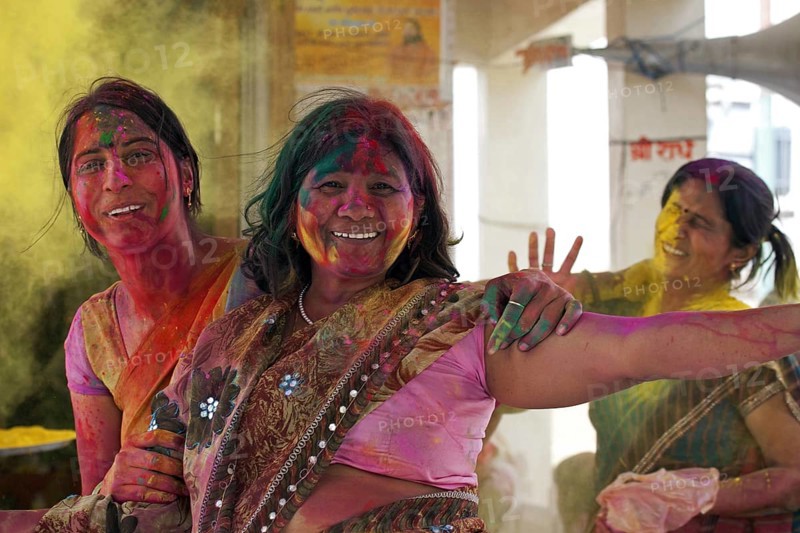 Women covered in colourful dye celebrating the Holi festival, Festival of Colours in Mathura, Uttar Pradesh, India, Asia