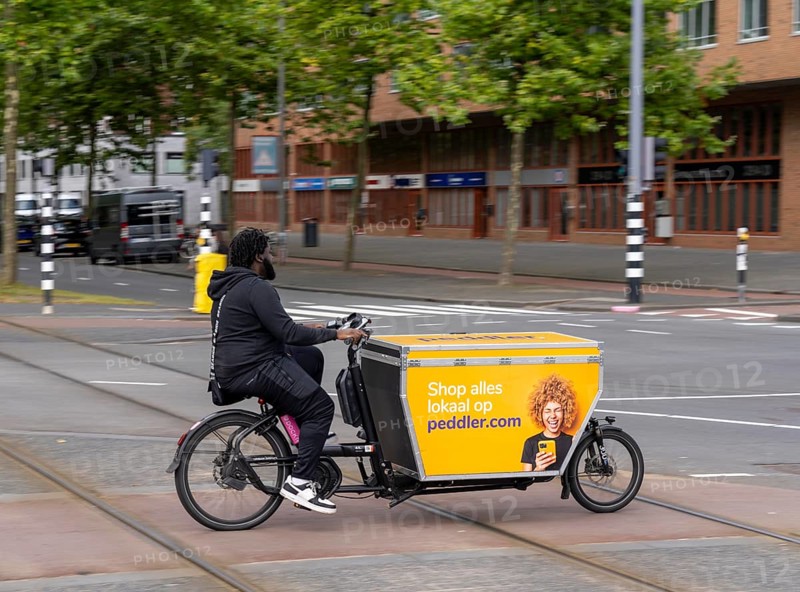 Cargo bike courier of the internet shopping platform peddler.com, delivery of all kinds of goods from local shops, Rotterdam, Netherlands