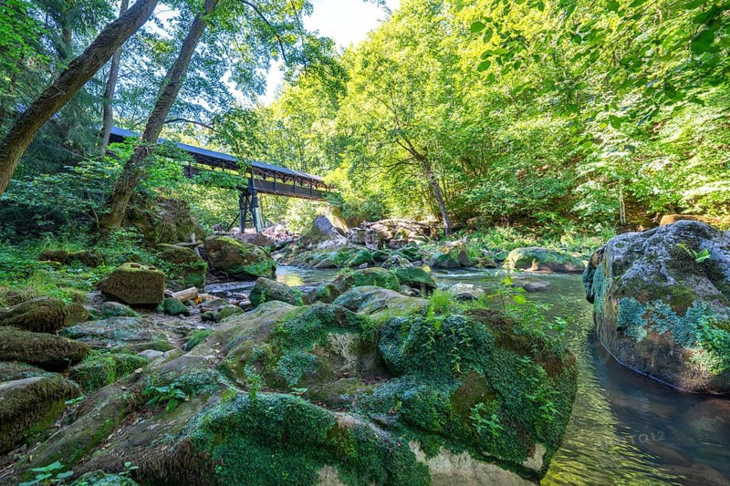 The Irrel Waterfalls, rapids in the lower reaches of the Prüm, covered wooden bridge for hikers, between Prümzurlay and Irrel, in the Eifel district of Bitburg-Prüm, Rhineland-Palatinate. Germany
