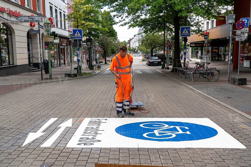 Application of road markings for a cycle lane, Rüttenscheider Straße in Essen, in the shopping and gastronomy district, cyclists have right of way over motorised vehicles, part of a cycle axis through Essen's city centre