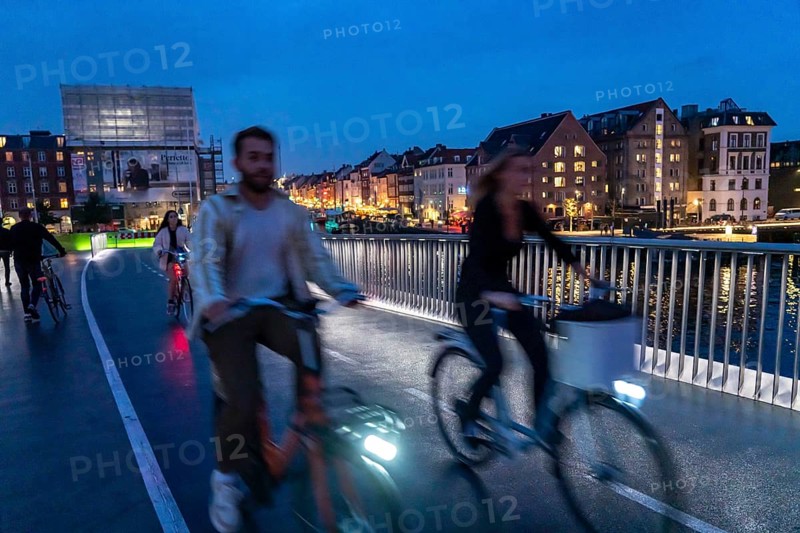 Cyclists on the Inderhavnsbroen cycle and footpath bridge, across the harbour, at night, at Nyhavn, Copenhagen is considered the cycling capital of the world, 45 % of the population travel by bike, Denmark, Europe