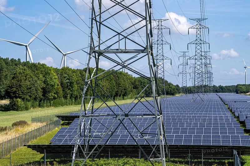 High-voltage power line route, the space underneath is used for a solar park over 5 km long, behind it a wind farm, in the harbour area of Vlissingen-Oost, Netherlands