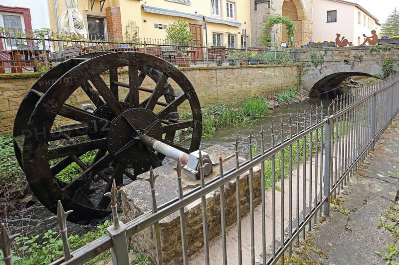 Waterwheel at the stream casting with metal fence, idyll, Meisenheim, Rhineland-Palatinate, Germany, Europe