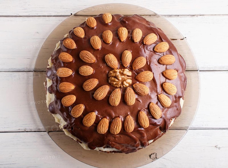 Homemade chocolate cake with almonds on white wooden background. top view, flat lay