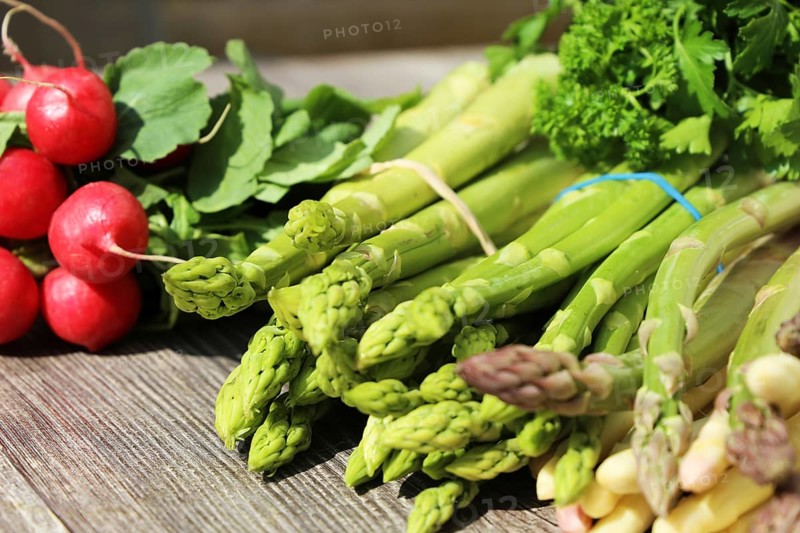 Green asparagus and white asparagus decorated on a rustic wooden table