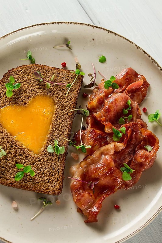Breakfast, fried egg with bacon, micro-green, on a light background, no people, selective focus