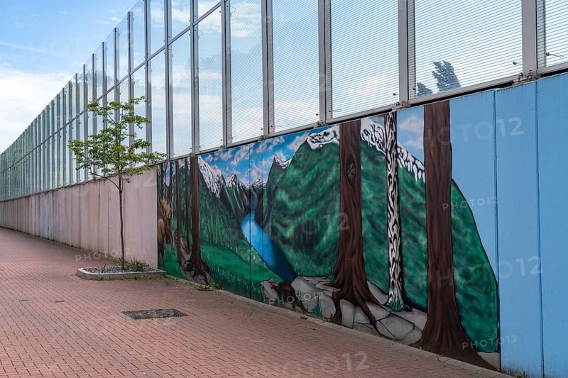 Noise barrier on Hombrucher Straße in Essen-Frillendorf, along the A40 motorway, 250 metres long, residents of a house have had a picture of a mountain lake painted on the grey concrete wall, as a more beautiful view, North Rhine-Westphalia, Germany, Europe