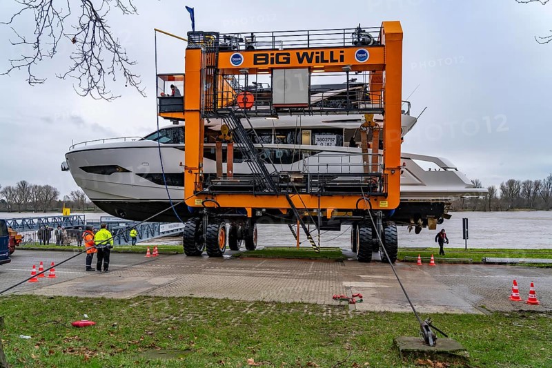 Craning the €6.3 million Sunseeker 88Y motor yacht, weighing 82 tonnes, in preparation for the world's largest water sports trade fair, Boot in Düsseldorf, luxury yachts are driven across the Rhine to the trade fair and brought ashore with the help of the Big Willi ship crane and transported to the exhibition halls on a low-loader, North Rhine-Westphalia, Germany, Europe