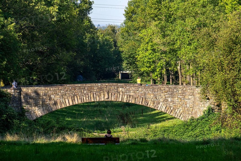The main cemetery in Dortumund-Brackel, the largest green space in the city and one of the largest cemeteries in Germany with an area of 118 hectares, central visual axis, in the park-like cemetery, with quarry stone bridge over a stream, Dortmund North Rhine-Westphalia, Germany, Europe