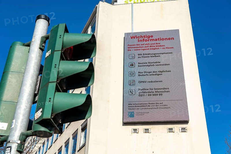 Advertising display on a house wall with information on corona, effects of the coronavirus pandemic in Germany, Düsseldorf