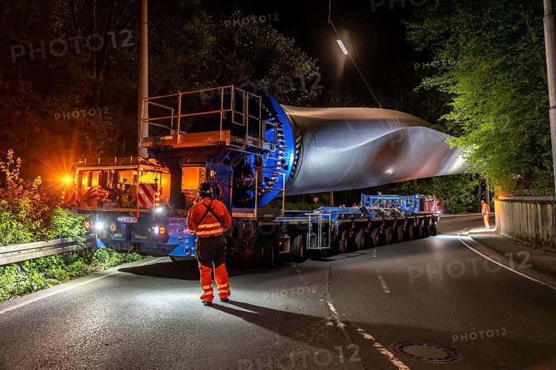 Transport of a 68 metre long, 22 tonne blade of a wind turbine, here in Schwelm, with a self-propelled Blade-Lifter vehicle, over a 40 km long route, over 2 nights, in the Bergisches Land, through towns, villages, over country roads, narrow through roads, to the construction site of the wind turbine near Hagen, North Rhine-Westphalia, Germany, Europe