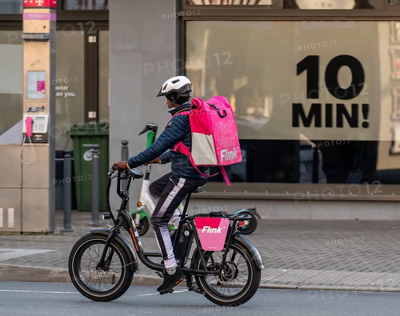 Bicycle courier of the fast delivery service Flink, delivers groceries, currently in over 40 German cities, within 10 minutes, orders via an app, works together with the REWE Group, in the background competitor Gorillas, Bochum, North Rhine-Westphalia, Germany, Europe