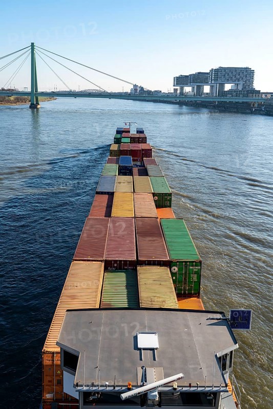 Container cargo ship on the Rhine, heading south, the crane houses in Cologne at the Rheinauenhafen, Cologne-South, residential and office buildings, Severinsbrücke, Cologne, North Rhine-Westphalia, Germany, Europe