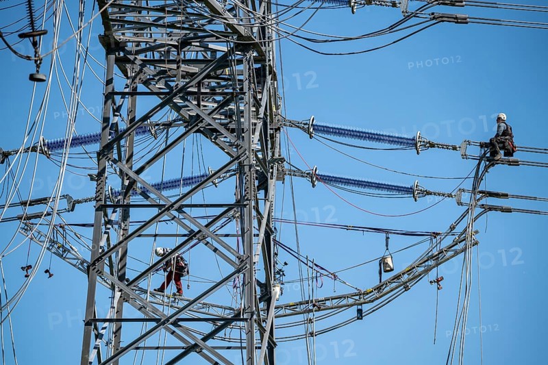 Construction of a new line route, 380 KV extra-high voltage line between Osterath and Gohr, near Neuss, fitter on a boom of an electricity pylon, at great height, North Rhine-Westphalia, Germany, Europe