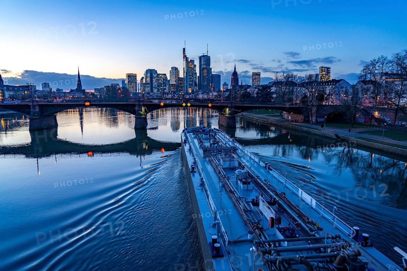 Skyline of the city centre of Frankfurt am Main, river Main, dusk, Ignatz-Bubis-Bridge, cargo ship, tanker, Hesse, Germany, Europe