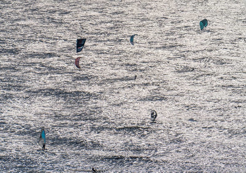 Kitesurfers and windsurfers in strong winds on the beach of Scheveningen, The Hague, Netherlands