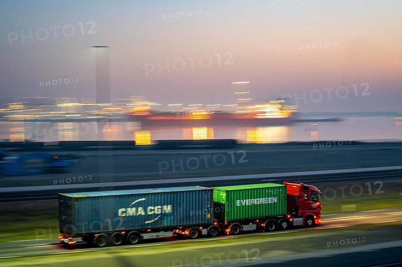 Lorry on the road from Euromax Terminal Rotterdam, ENECO wind farm on the dike around the port of Maasvlakte 2, 22 wind turbines with a capacity of 116 megawatts, sunset, Rotterdam, Netherlands Evergreen Container