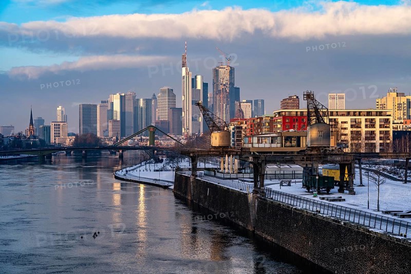 The skyline of Frankfurt am Main, skyscrapers of the banking district, historic harbour cranes at the Wesel shipyard, wintry morning, Hesse, Germany, Europe