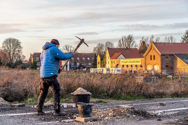 Climate activists chop up the asphalt of a road to erect obstacles, barricades, to prevent the police from evicting the occupied hamlet of Lützerath, the remains of the village are to make way for lignite mining, an eviction is imminent, North Rhine-Westphalia, Germany, Europe