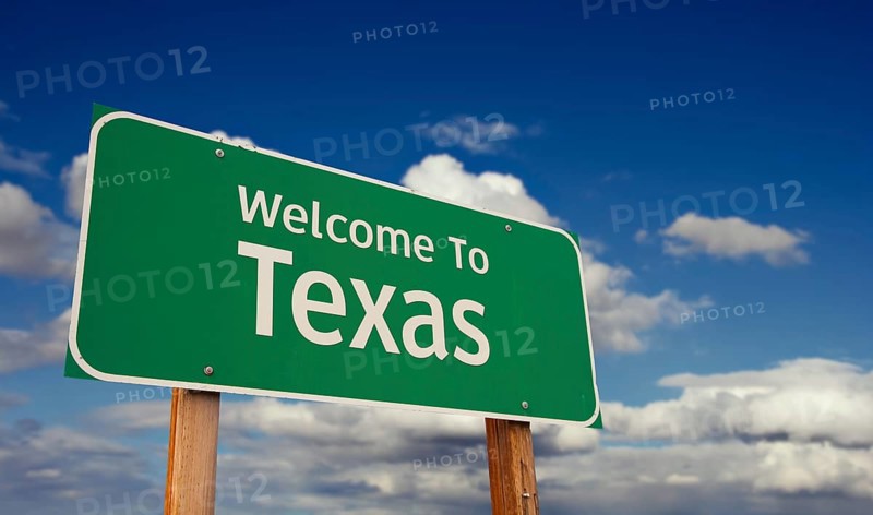 Welcome to texas green road sign over blue sky with some clouds