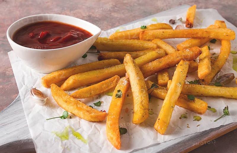 Fried French fries, in a paper bag, on an abstract background, no people, rustic