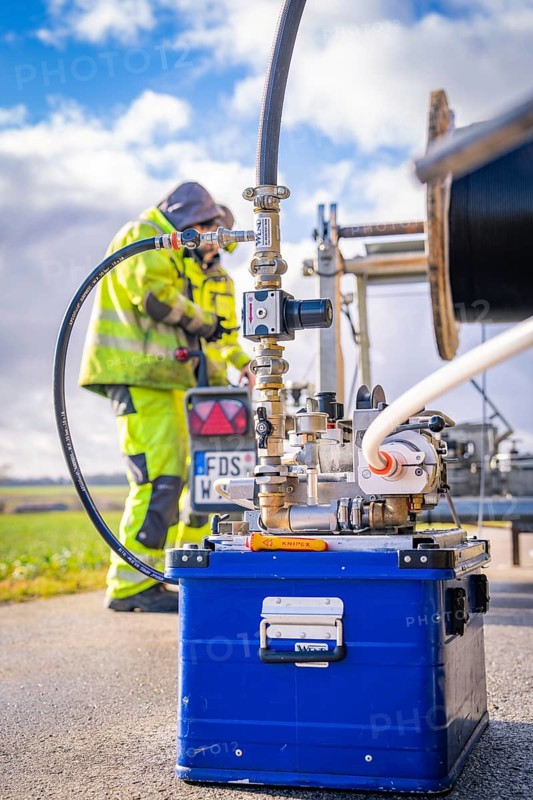 Worker in protective equipment operates outdoor machine with hoses and metal parts, glass fibre construction, Nagold, Black Forest, Germany, Europe