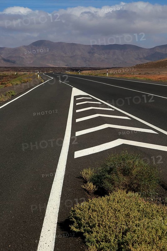 Chevron road lines on main highway through Malpaís Grande national park, Fuerteventura, Canary Islands, Spain, Europe