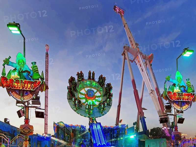 People on the illuminated carousel Mr Gravity in the evening, Cranger Kirmes, Herne, Ruhr area, North Rhine-Westphalia, Germany, Europe