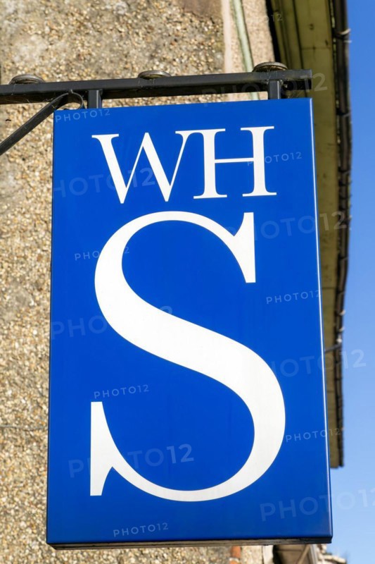 Close up of WH Smith brand logo sign mounted on wall, Hungerford, Berkshire, UK