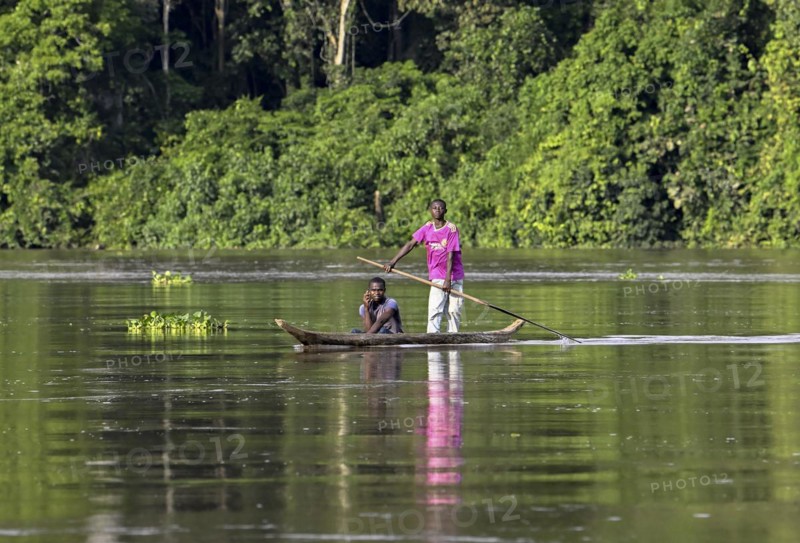 Two young men in a dugout canoe on the Sangha River, Dzanga-Sangha Complex of Protected Areas (DSPAC), Sangha-Mbaéré Prefecture, Central African Republic, Africa