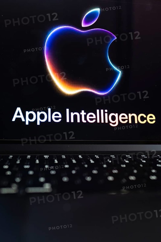 Apple logo in bright neon colours on a Macbook with illuminated keyboard and the text 'Apple Intelligence' underneath, symbolic image of artificial intelligence