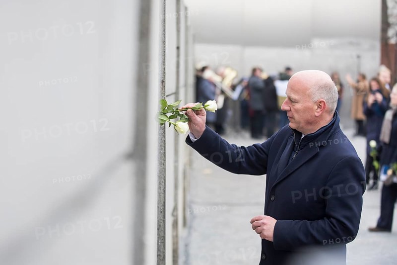 Kai Wegner (Governing Mayor of Berlin) sticks a rose into the Wall at the central commemorative event at the Berlin Wall Memorial to mark the 35th anniversary of the fall of the Wall in Berlin, 9 November 2024