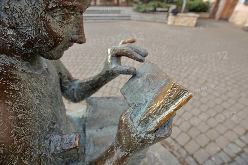 Sculpture Book reader at the fountain in front of the city library, literature, reader, book, reading, head, face, figure, holding, hand, finger, literature, detail, bronze sculpture, Pfleghof, Langenau, Alb-Donau-Kreis, Swabian Alb, Baden-Württemberg, Germany, Europe