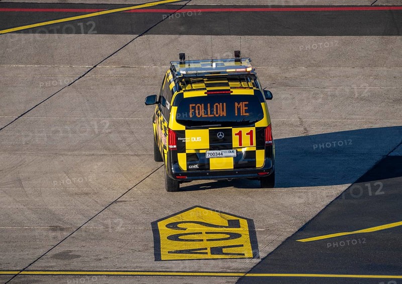 Follow Me vehicle, pilot vehicle, apron supervisor, marshal, directs an aircraft to its parking position, at Düsseldorf Airport, DUS North Rhine-Westphalia, Germany, Europe