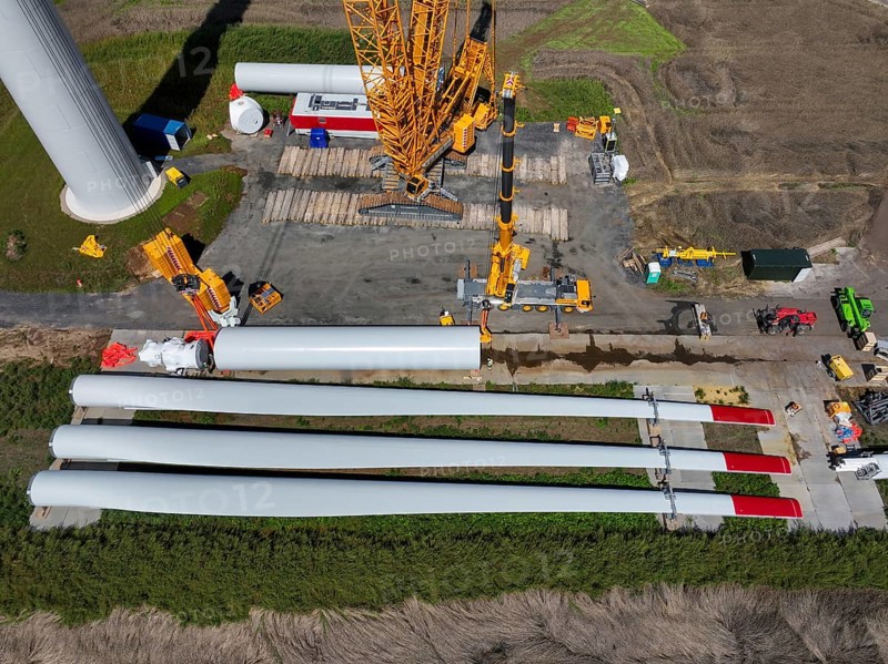 Dorsten, North Rhine-Westphalia, Germany, construction of a wind turbine, the first wind turbine of the Grosse Heide wind farm. The rotor blades are ready for assembly. A large mobile crane places the tower elements, the rings, on top of each other. This wind turbine will have a rated output of 5, 500 kW, Europe