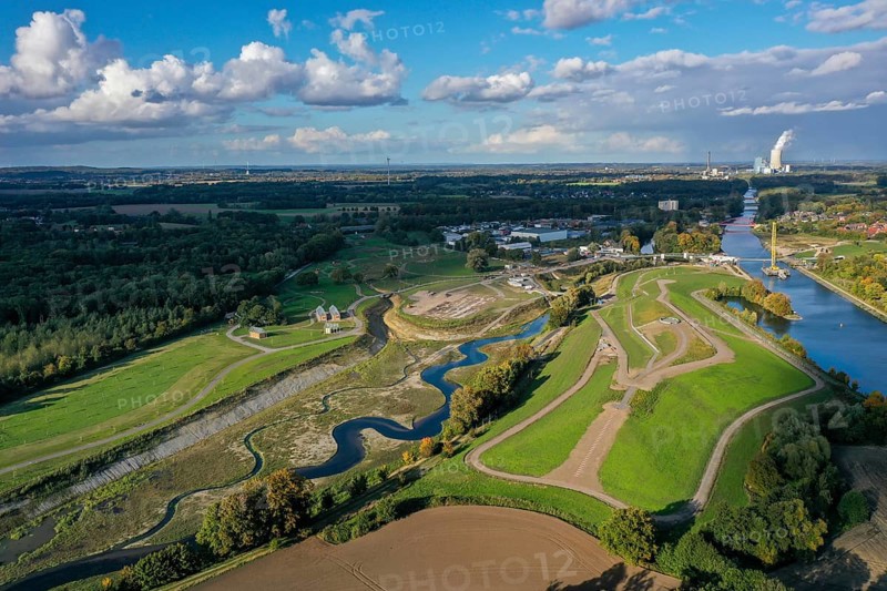 Recklinghausen, Castrop-Rauxel, North Rhine-Westphalia, Germany, EMSCHERLAND construction project, a 37-hectare water and nature discovery park at the water crossroads of the Rhine-Herne Canal (right) and the renaturalised Emscher (centre) on the city limits of Recklinghausen and Castrop-Rauxel. The ecological focal point at the confluence of Suderwicher Bach and Emscher will also be a future garden for the International Garden Exhibition 2027. Before the renaturalisation, the Emscher river system was an open, above-ground wastewater canal, combined sewer with surface water and wastewater. On the right, a new bridge is being built - a foot and cycle bridge over the Emscher and the Rhine-Herne Canal. The Uniper power plant Datteln 4 is in the background, Europe