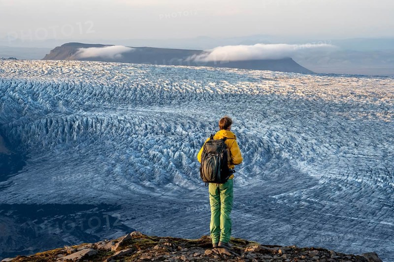Young man, tourist in front of impressive glacier, in the evening light, glacier tongues Kötlujökull, Myrdalsjökull glacier Pakgil, Iceland, Europe