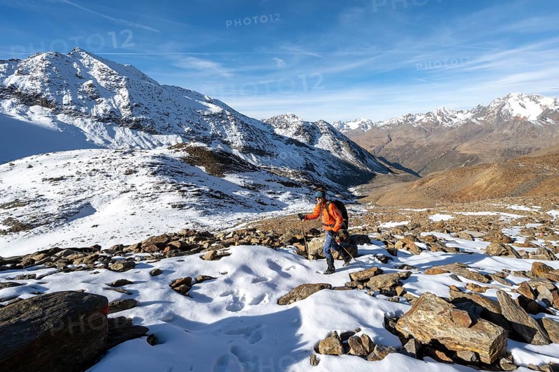 Mountaineer on a hiking trail with snow, descent from Ramoljoch at Spiegelferner, autumnal mountain landscape, mountain panorama with summit Wildspitze, Ötztal Alps, Tyrol, Austria, Europe