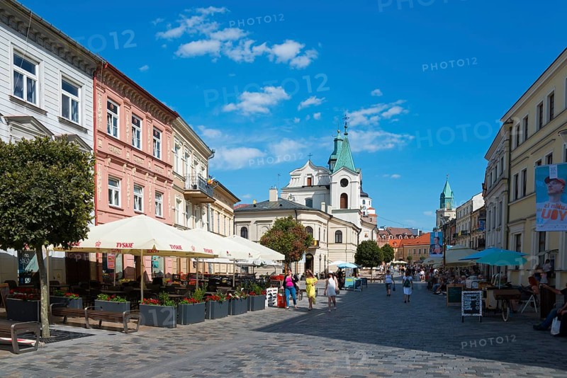 Lively historic street with church, cafés and passers-by under a blue sky, Church of the Holy Spirit, Krakowskie Przedmiescie Street, Lublin, Poland, Europe