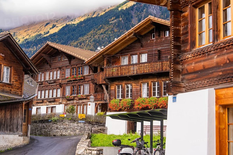 Village street with traditional wooden houses in the Alps against a mountain backdrop, Lake Brienz, Brienz, Switzerland, Europe