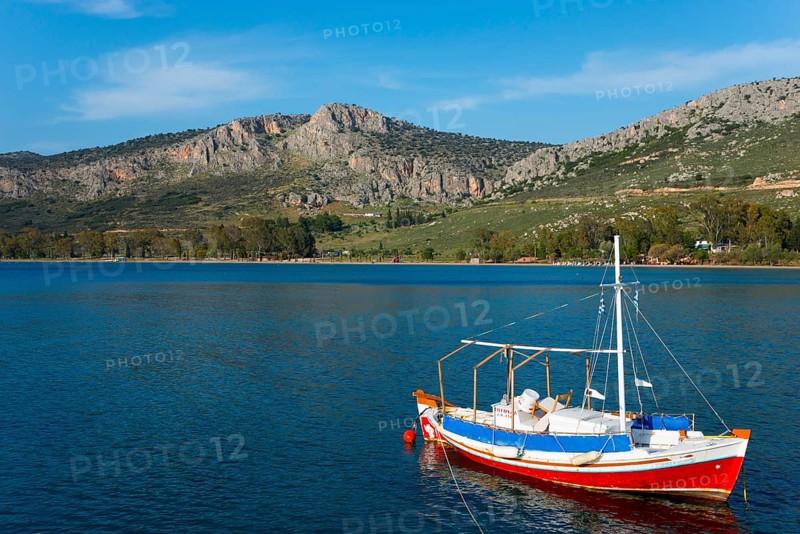 Small boat on a calm sea with mountains and blue sky in the background, Agia Kyriaki, Nafplio, Nauplia, Nauplion, Nafplion, Argolis, Argolic Gulf, Peloponnese, Greece, Europe