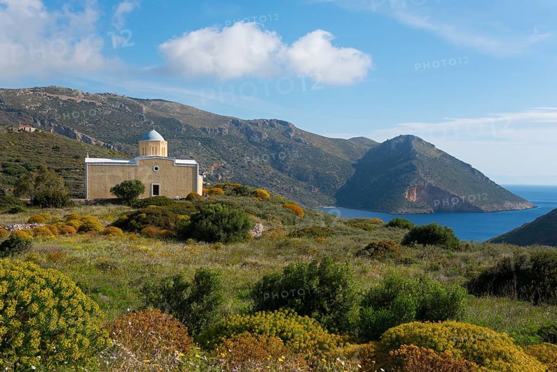 Small church by the sea with mountain backdrop under blue sky, surrounded by green landscape, Chiesa di Agia Triada, church near Marmari, Anatoliki Mani, Mani, Laconia, Laconia, Peloponnese, Greece, Europe