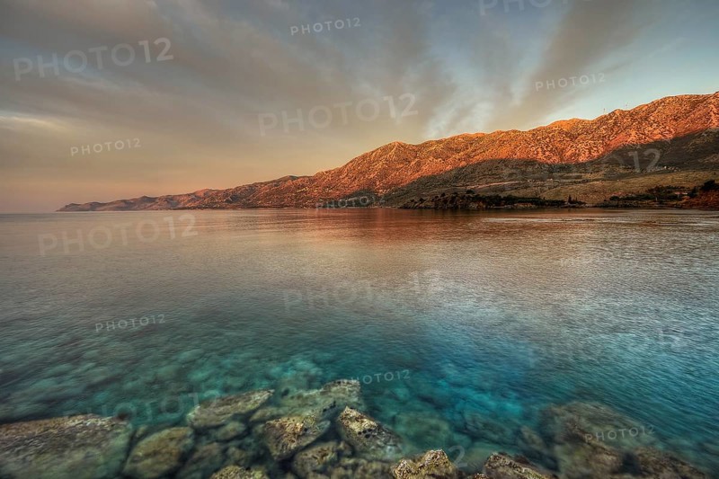 Morning light falls on a rocky coast with clear sea water, Mani peninsula, Peloponnese, Greece, Europe