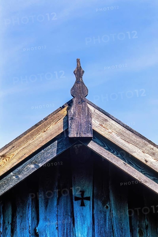 Gable and the rooftop on an old wooden cottage with a cross on the wall, Sweden, Europe